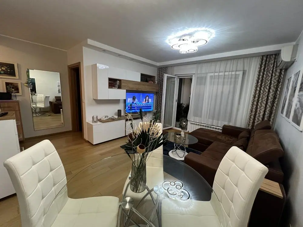 Dnevni boravak sa trpezarijskim stolom i izlazom na lođu — Zemunske kapije, Šumadijska — dvosoban stan, 51 m²