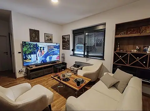 Dnevna soba sa televizorom, foteljama i ugradnim regalom