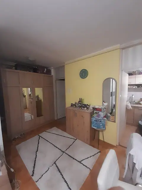 Soba sa plakarom sa ogledalima i pogledom ka kuhinji
