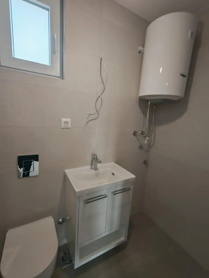 Kupatilo sa lavaboom, konzolnom WC šoljom i bojlerom