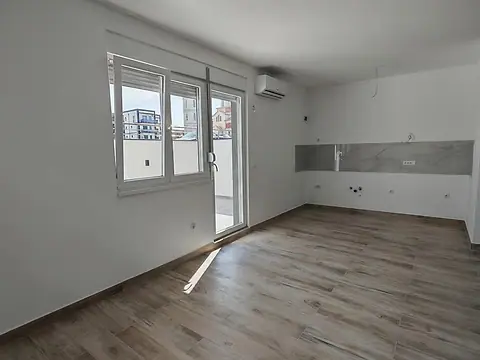 Dnevni prostor sa kuhinjskim zidom i izlazom na dvorište