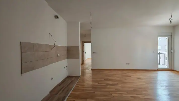 Dnevni prostor sa kuhinjskim zidom i izlazom na terasu